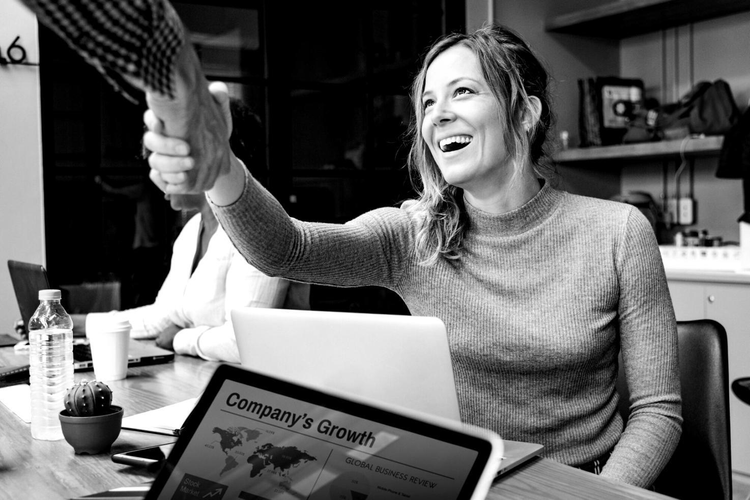Person arbeitet konzentriert an Budgetplanung am Computer mit Taschenrechner und Dokumenten
